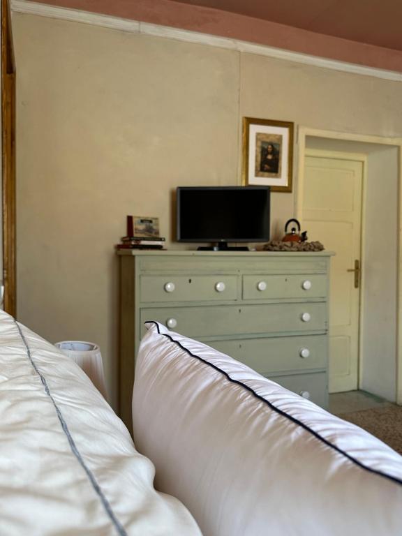 a bedroom with a dresser and a bed with a pillow at Villa Sibilla in Barga