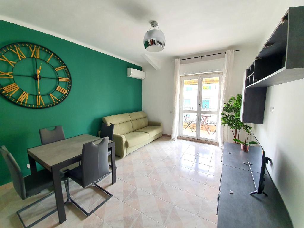 a living room with a clock on a green wall at enea apartment in Rome