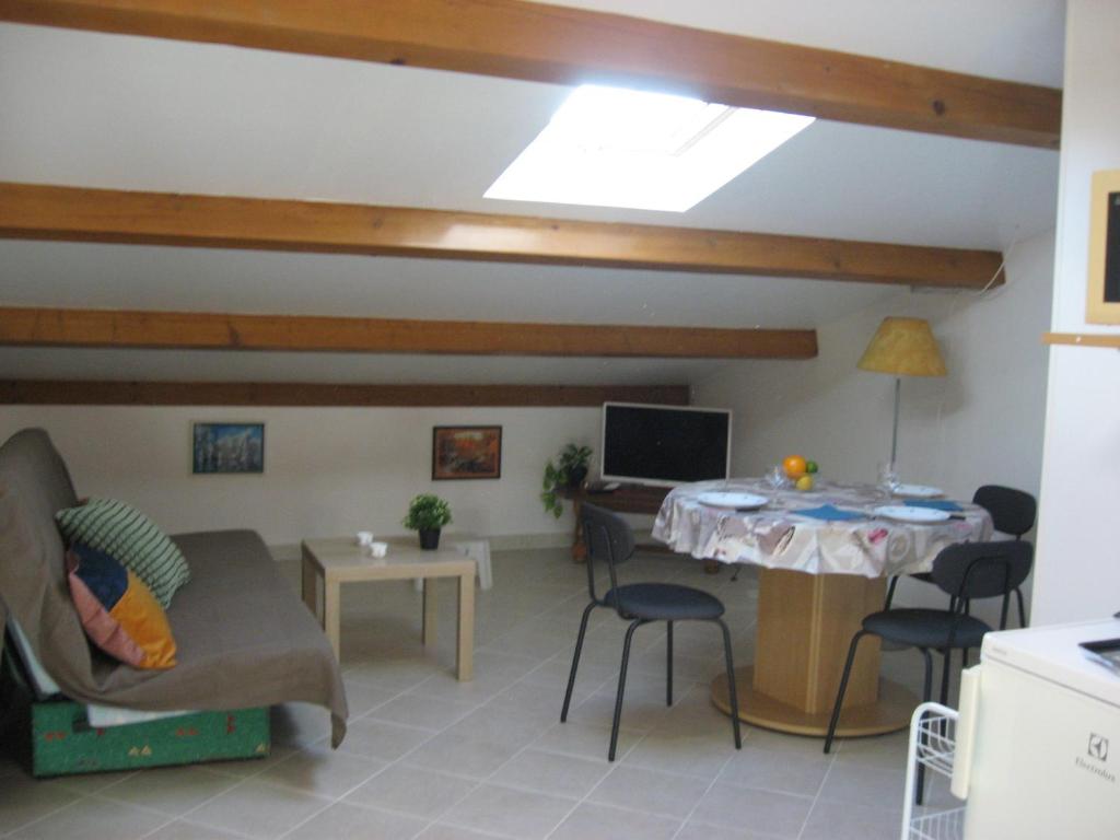 sala de estar con sofá y mesa en T 2 avec velux au 1er étage de 34 m2, en La Londe-les-Maures