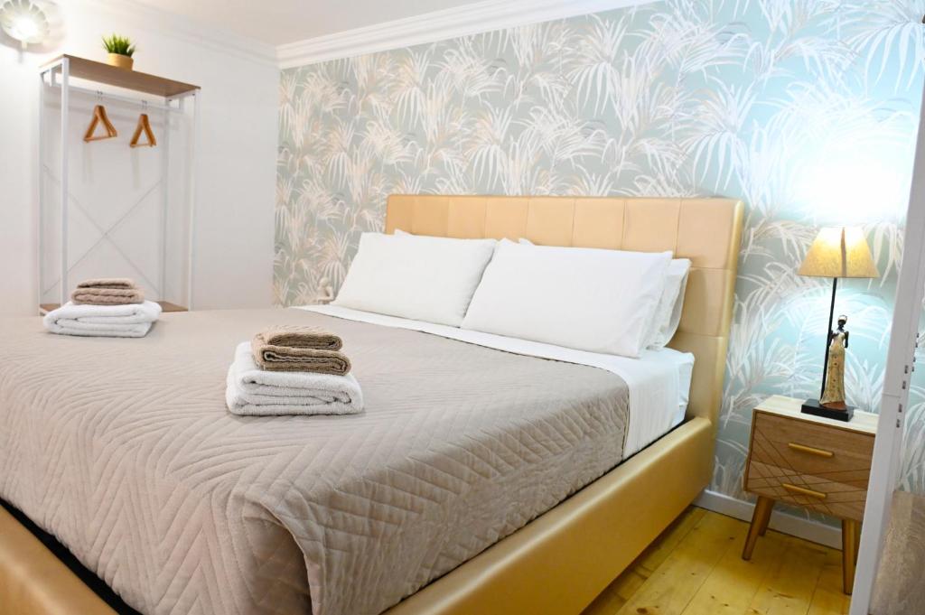 a bedroom with a bed with towels on it at Victry's Houses Chiaia in Naples