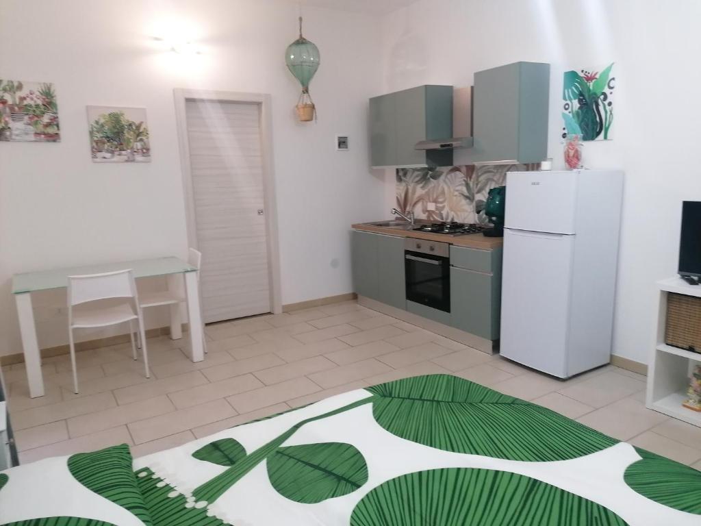 een keuken met een witte koelkast en een tafel bij Casa d'Arte 1 in Gravina di Catania