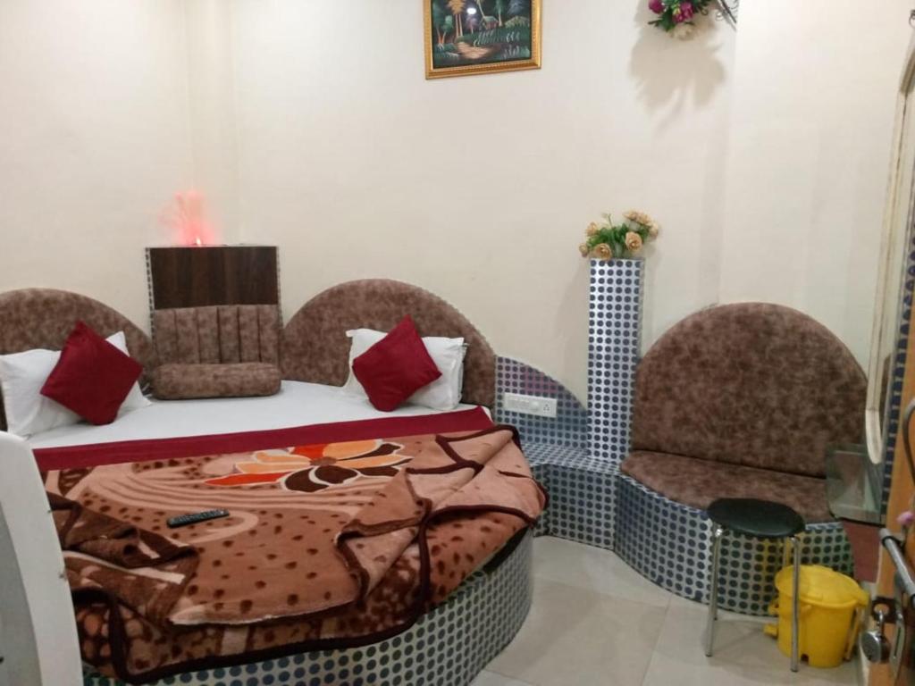 a room with a bed and two chairs and a table at Hotel Amar palace pachmarhi in Pachmarhī