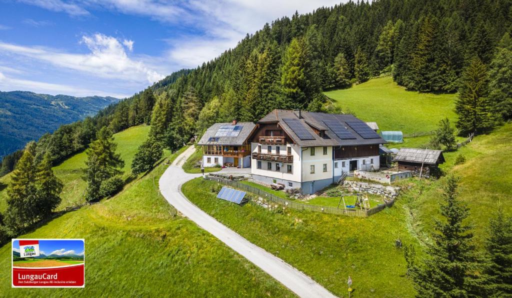 een groot huis op een heuvel met een weg bij Ferienhaus Krametergut in Sankt Michael im Lungau