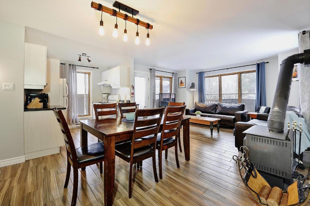 a kitchen and living room with a table and chairs at 16 Chemin Alpin in Stoneham