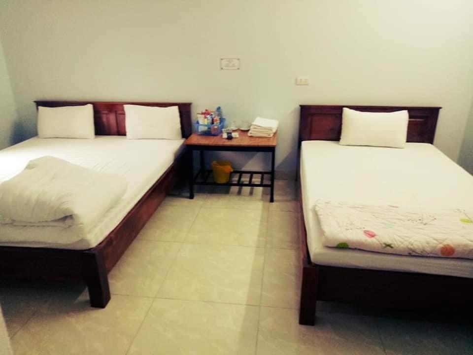 um quarto com duas camas e uma mesa com mesa de cabeceira em Nhà Nghỉ Việt Hùng em Mai Châu