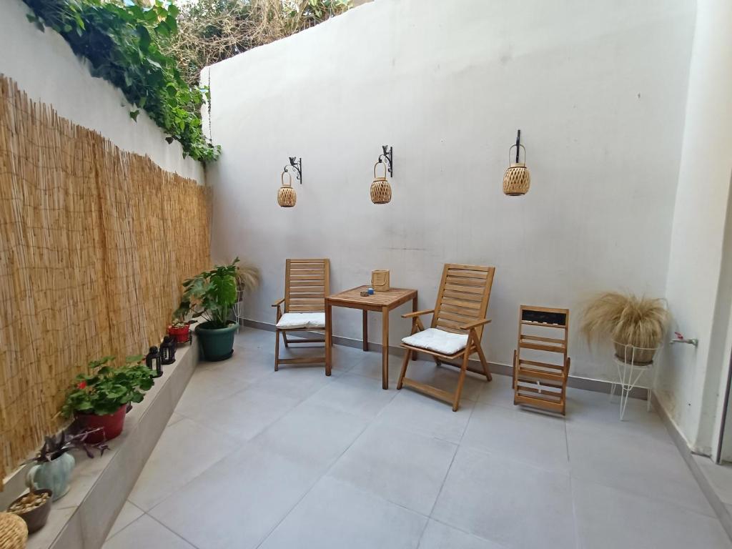 eine Terrasse mit Stühlen und einem Tisch an der Wand in der Unterkunft Unique Lodging in Athen