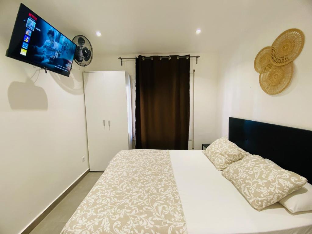 1 dormitorio con 1 cama y TV de pantalla plana en Apartamentos LH frente al metro Barcelona-Aeropuerto, en Hospitalet de Llobregat