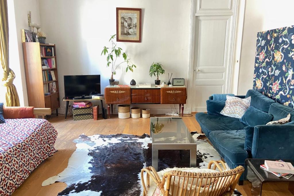 een woonkamer met een blauwe bank en een tafel bij Cozy apartment in a lively Nice district in Nice