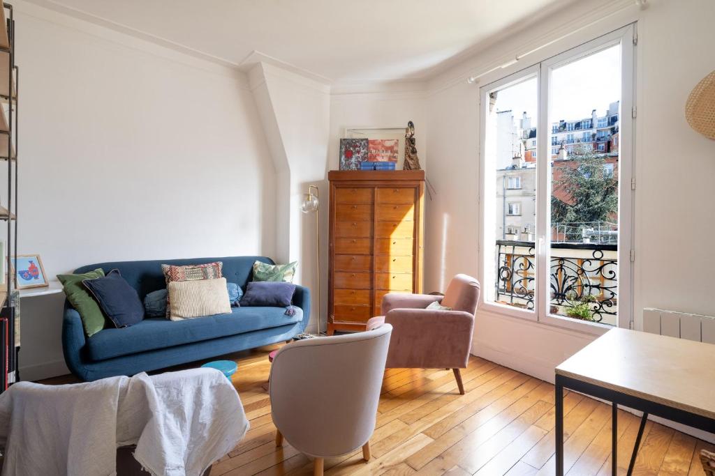 sala de estar con sofá azul y mesa en Nice apartment in the heart of Paris - Welkeys en París