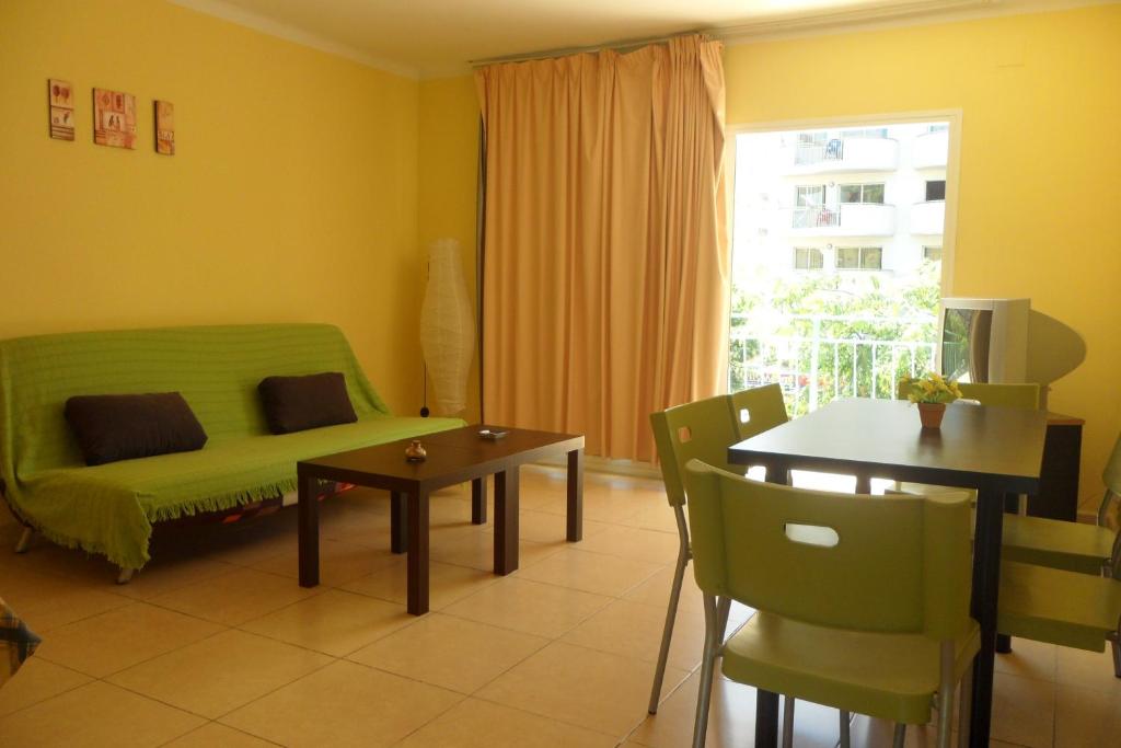 een woonkamer met een groene bank en een tafel bij Rex Apartment in Salou