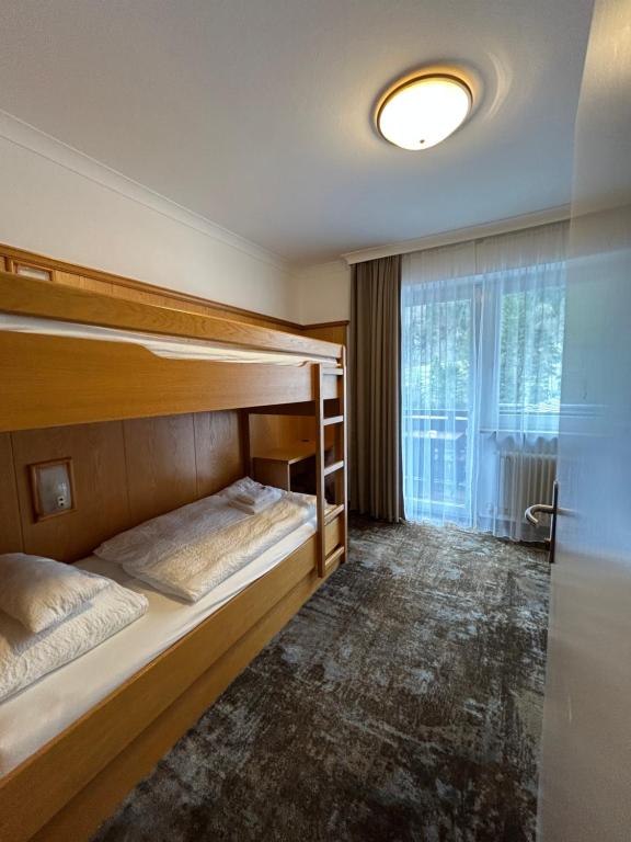 two bunk beds in a room with a window at Pension Baranekhof - accommodation in nature - Baranek Resorts in Kaprun