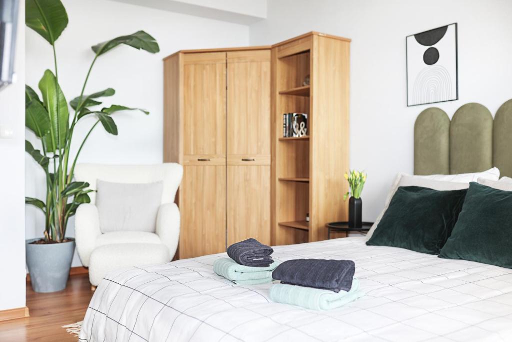a bedroom with a bed with a chair and towels on it at Apartament Kokpit in Piła