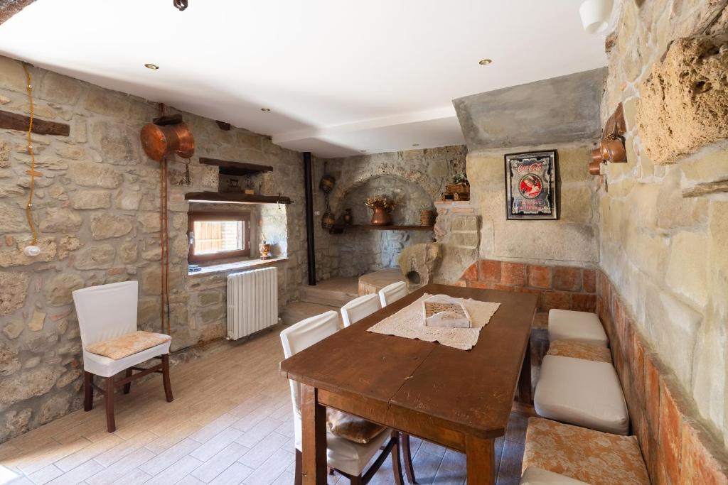 Aquasanta的住宿－Casa Vacanze “Rocca dei sogni”，一间带木桌和椅子的用餐室