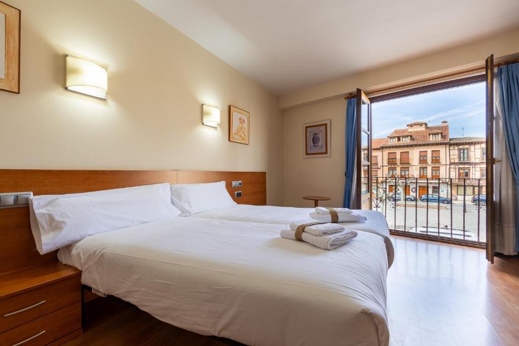 1 dormitorio con 1 cama grande y ventana grande en Hotel Zaravencia Plaza Mayor by InsideHome, en Toro