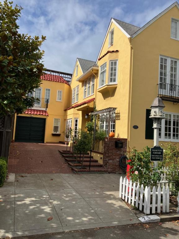 a row of yellow houses with a white fence at My Rosegarden Guest Rooms in San Francisco