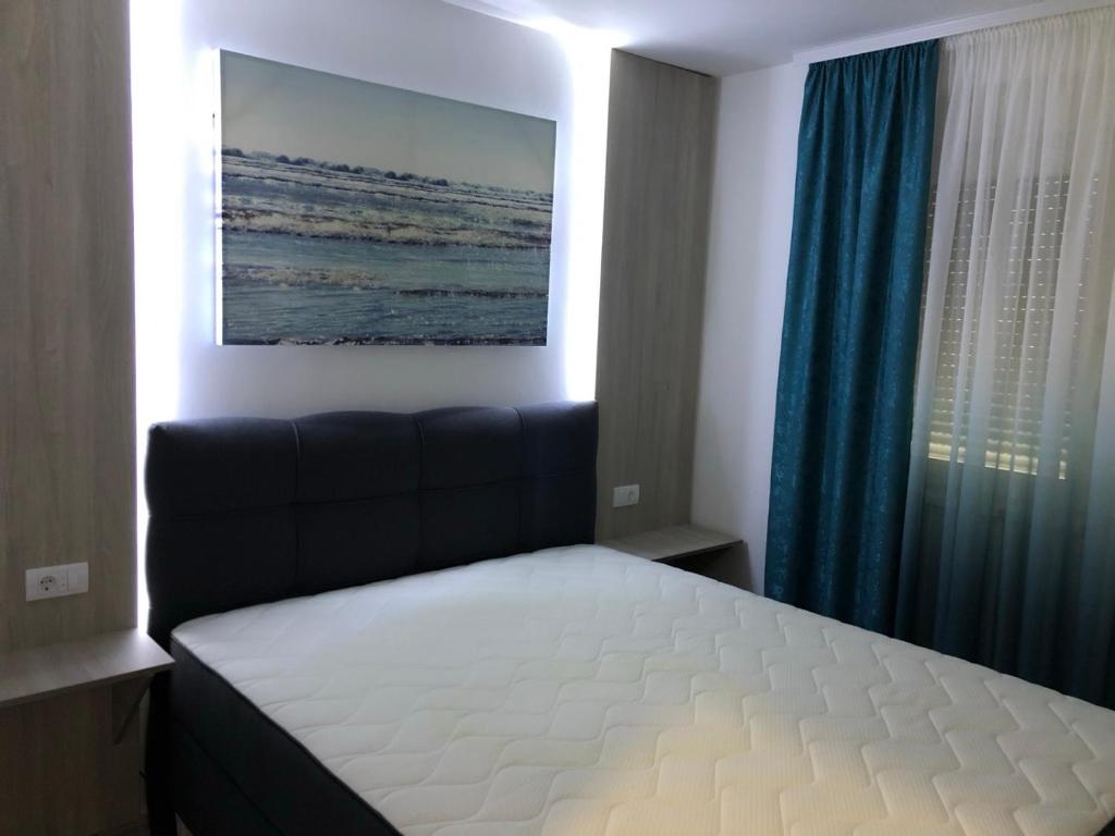 een slaapkamer met een bed en een blauw gordijn bij Romantika 3 in Ostrovo