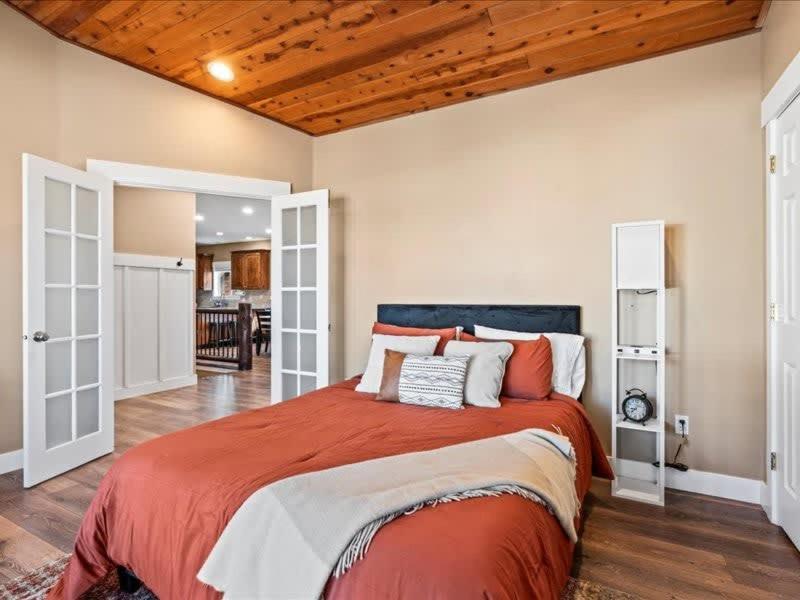 a bedroom with a large bed with red comforter at Downtown Heber Hangout in Heber City