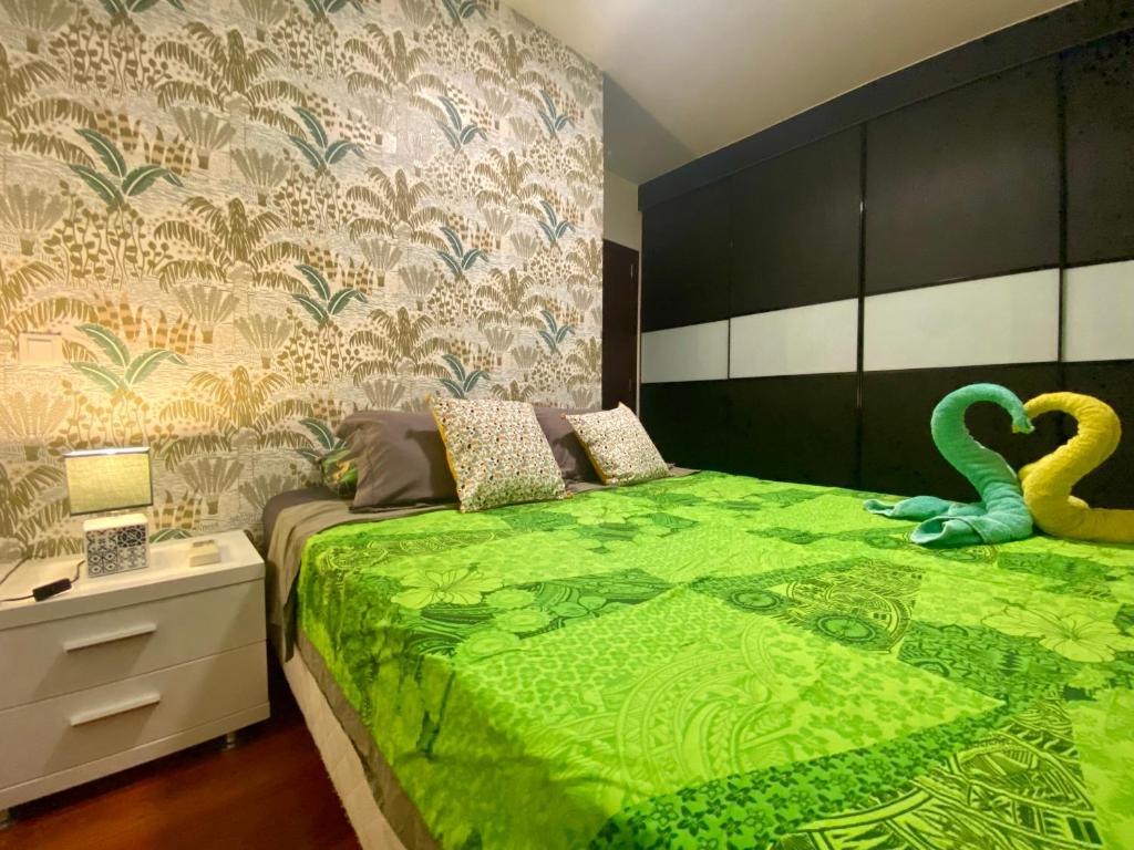 Apartment Heitiare في بابيت: غرفة نوم بسرير اخضر عليها بجعتين