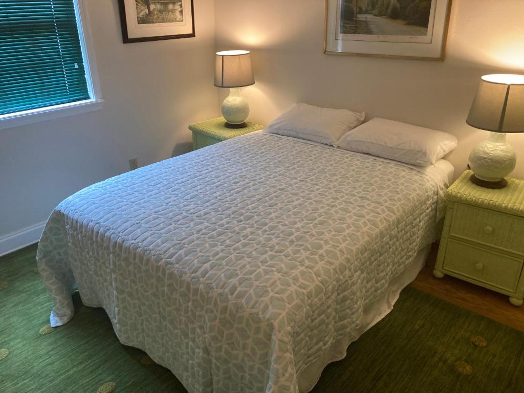 1 dormitorio con 1 cama blanca y 2 mesitas de noche en Green garden view, en Nueva Orleans