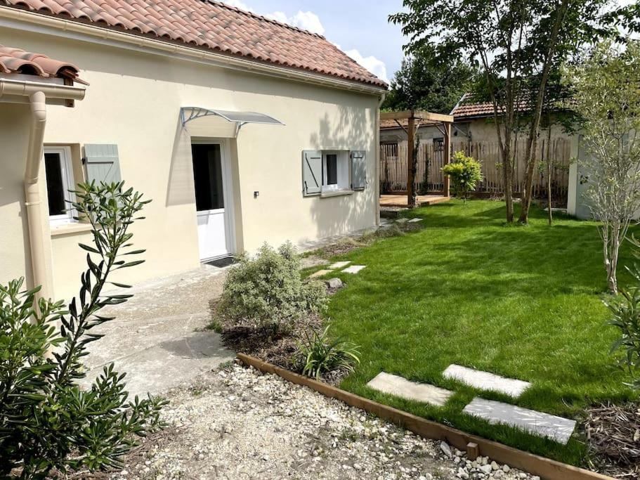 um quintal de uma casa com um relvado sidx sidx sidx em Petite maison avec jardin au calme em Floirac