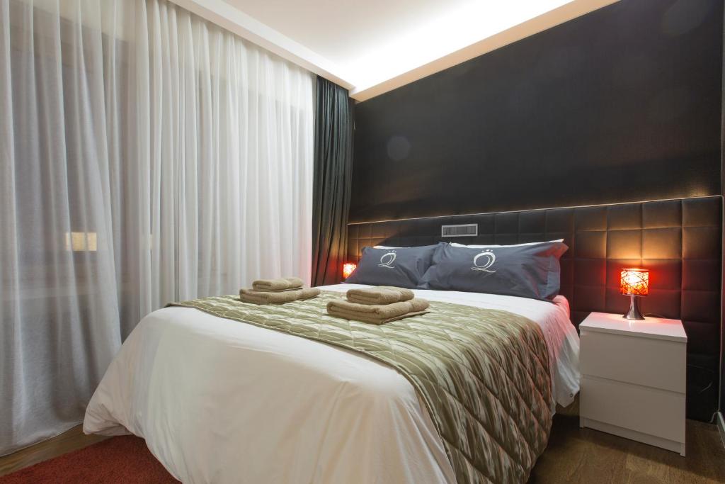 Un dormitorio con una cama grande con dos toallas encima. en The Queen Luxury Apartments - Villa Medici, en Luxemburgo