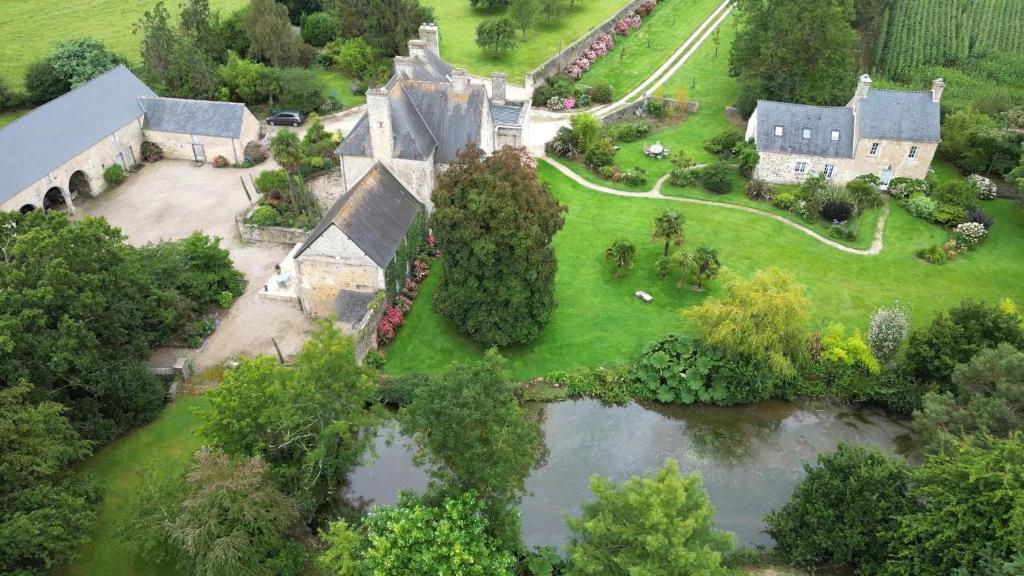 an aerial view of an old house with a pond at Le cottage de Savigny in Valognes