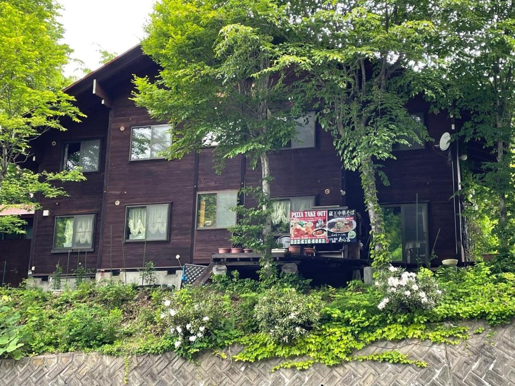 Zao Pension Aramiya - Vacation STAY 40314v في Kaminoyama: منزل خشبي وامامه لافته