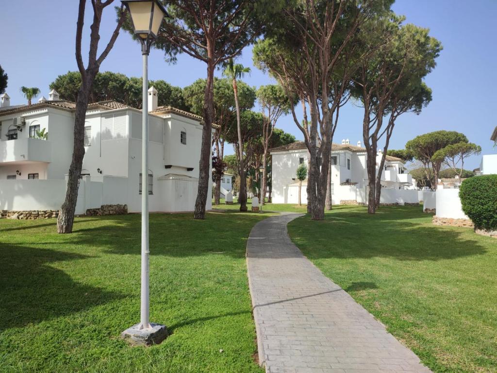 a street light in a park with trees and houses at Apartamento Pinar del Atlántico La Barrosa in Chiclana de la Frontera