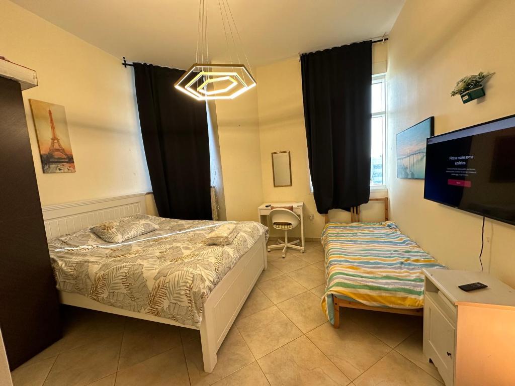 a bedroom with a bed and a flat screen tv at Master Bed Room Shared Apartment Flat 1301 in Abu Dhabi