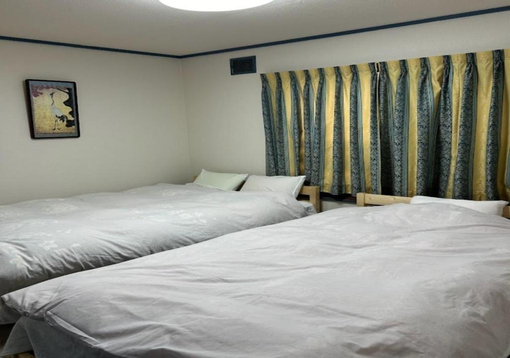Ota Apartment - Vacation STAY 16061 في أوتارو: سريرين يجلسون بجانب بعض في غرفة