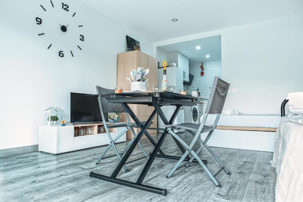 Una mesa y dos sillas en una habitación con reloj en Apartamento Brisa Playa, en Aguadulce