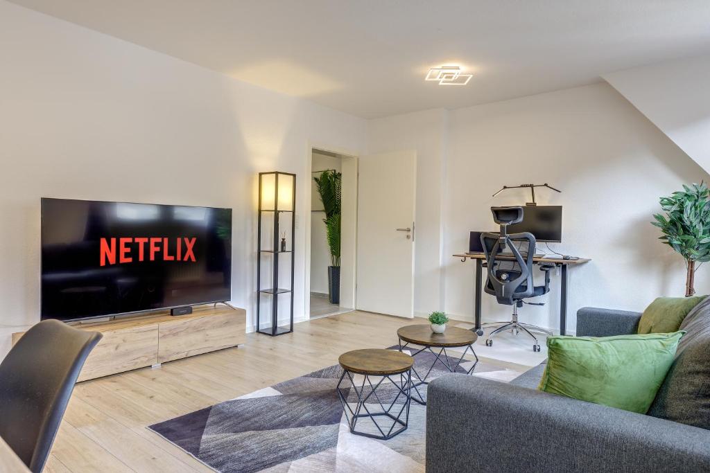 a living room with a tv and a couch at K&M - Das Apartment - Zentral - Mit Arbeitsplatz in Wiesbaden