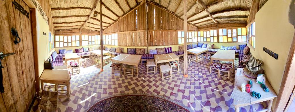 Camping auberge palmeraie d'amezrou في زاكورة: اطلالة علوية لغرفة بها طاولات وكراسي