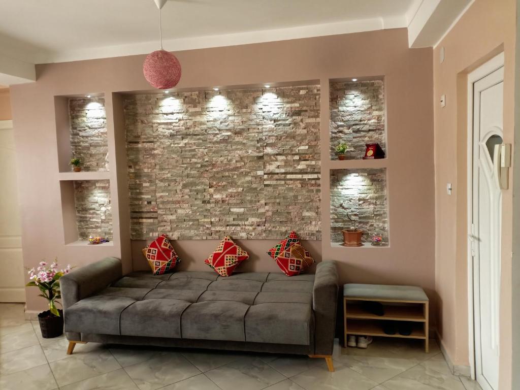 ein Wohnzimmer mit Sofa und Ziegelwand in der Unterkunft JolieVue in Bejaïa