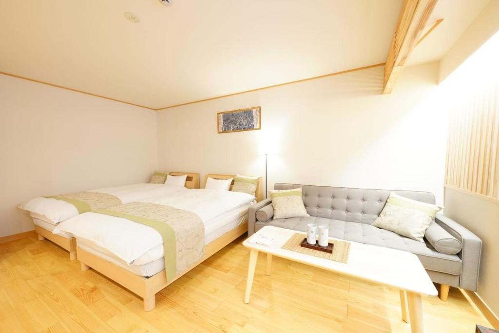 um quarto com uma cama e um sofá em Yadoya Hototogisu - Vacation STAY 37442v em Tóquio