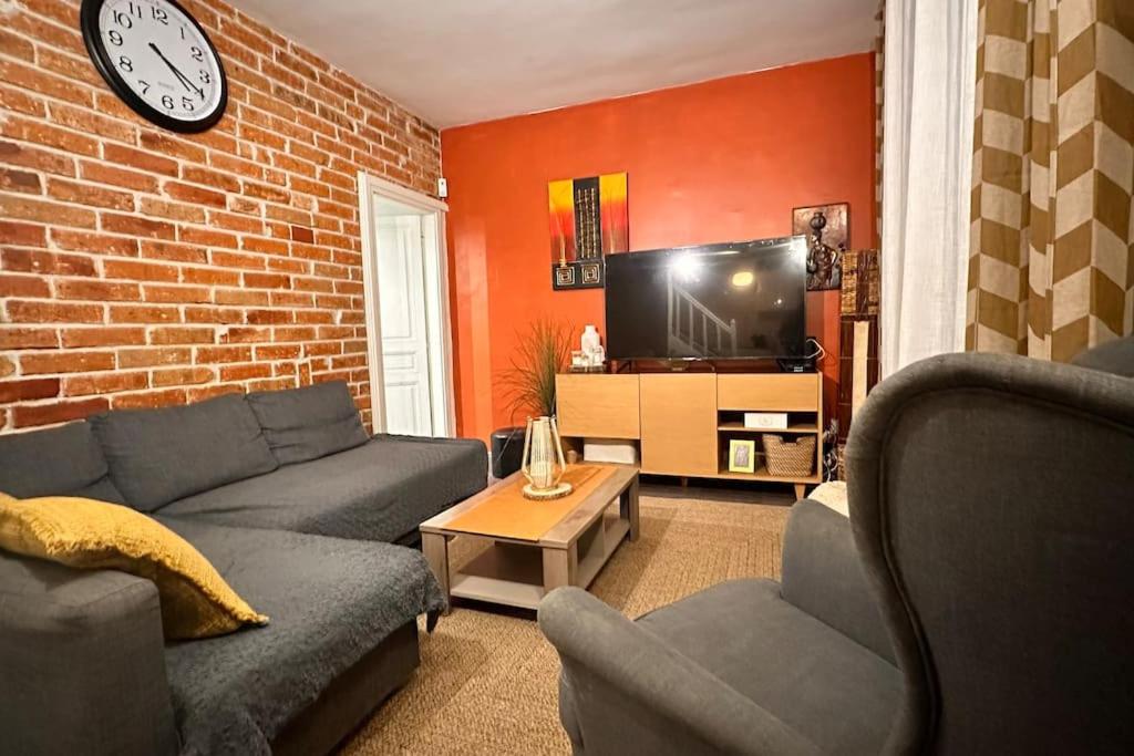 a living room with a couch and a tv at The house of little Paris in Montreuil