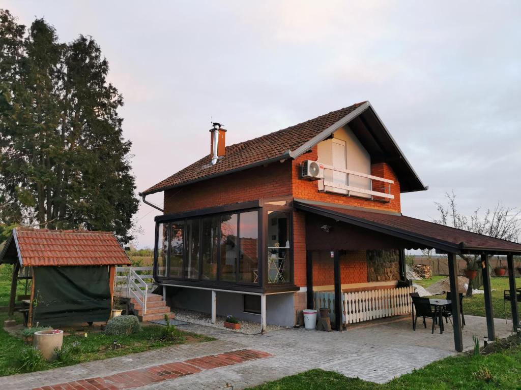 una casa pequeña con muchas ventanas en Kuća za odmor Bella en Sotin