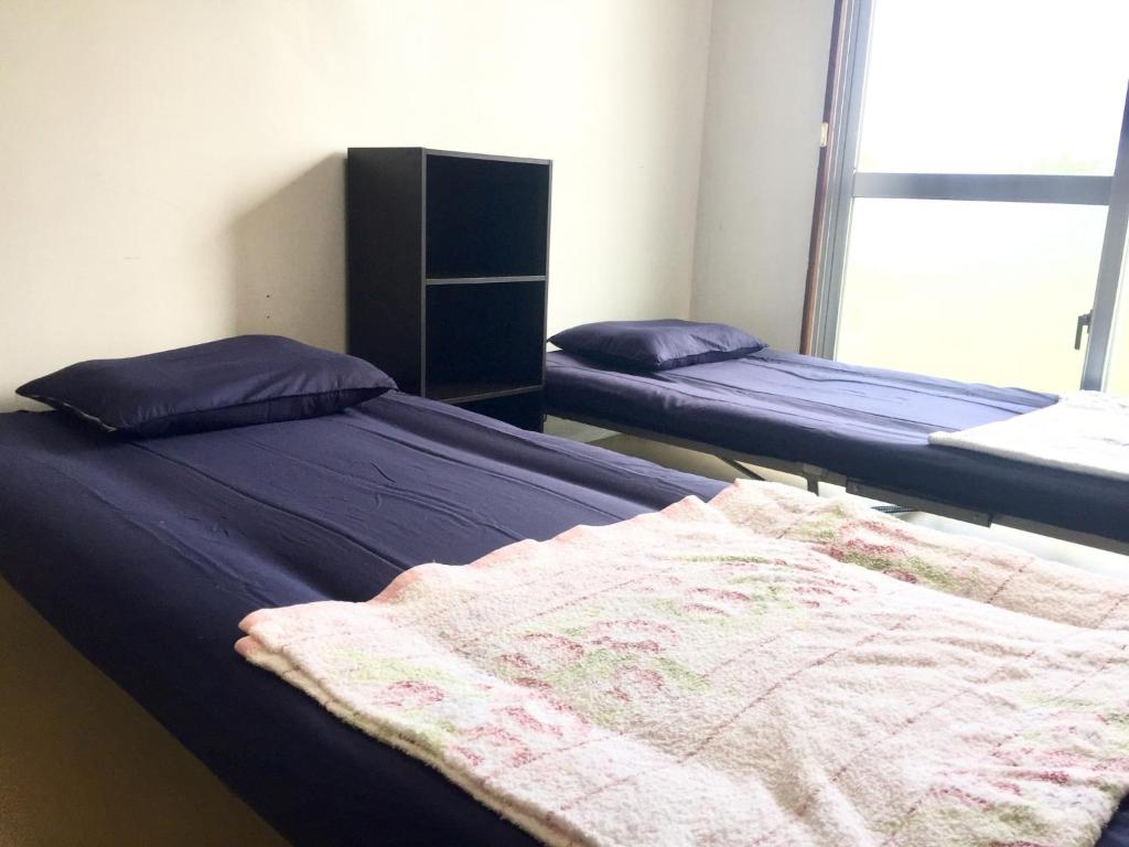 2 Betten in einem Zimmer mit lila Bettwäsche in der Unterkunft Shimaotoya - Vacation STAY 39962v 