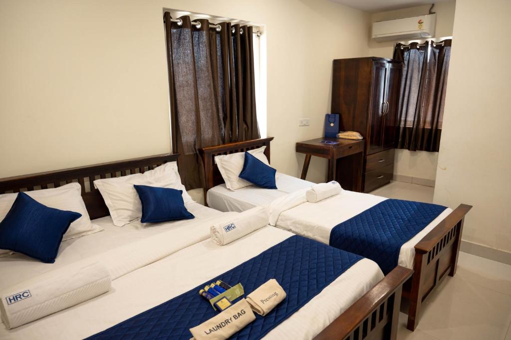 - une chambre avec 2 lits dotés d'oreillers bleus et blancs dans l'établissement nbr stays, à Hyderabad