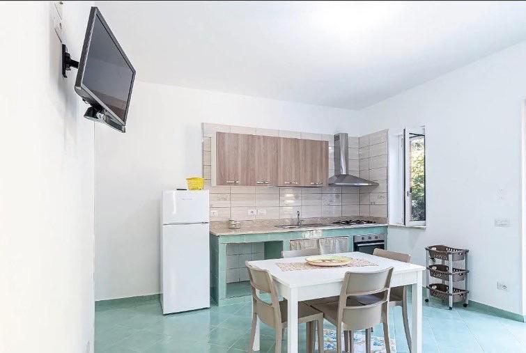 cocina con mesa blanca y nevera blanca en Villa Anna, en Palinuro