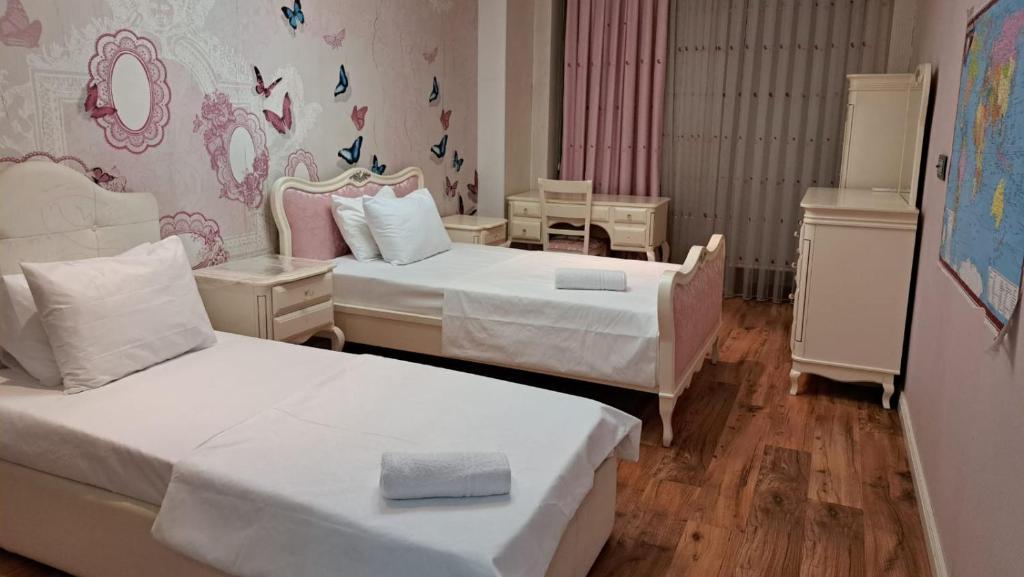 a bedroom with two beds and a wall with butterflies at Vip Apartment Azure Tower in Baku