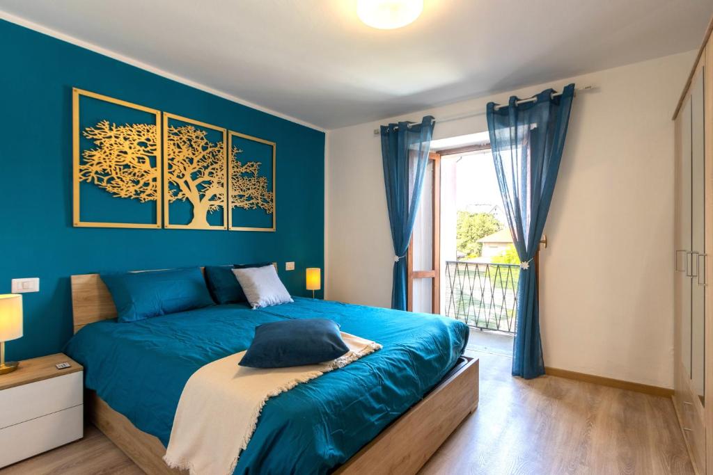 ein blaues Schlafzimmer mit einem Bett und einem Fenster in der Unterkunft Golden Lake - Luxury Apartment ☆☆☆☆☆ - 100m from the lake in Baveno