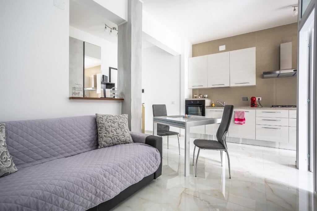 un soggiorno con divano e tavolo con sedie di Portside Aparthotel a Roma