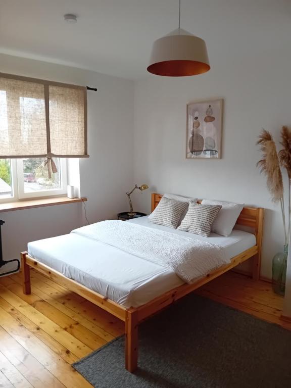 una camera da letto con letto, lenzuola e cuscini bianchi di Daugavas apartamenti a Ogre