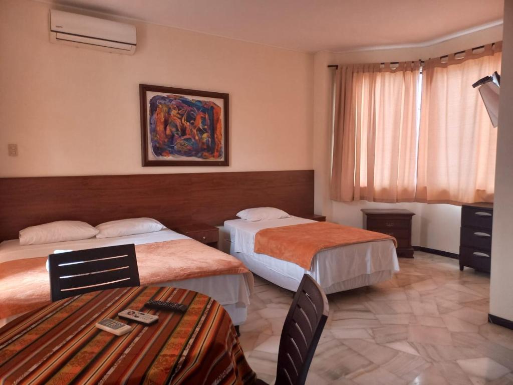 una camera d'albergo con due letti e un tavolo di GARZOQUIL a Guayaquil