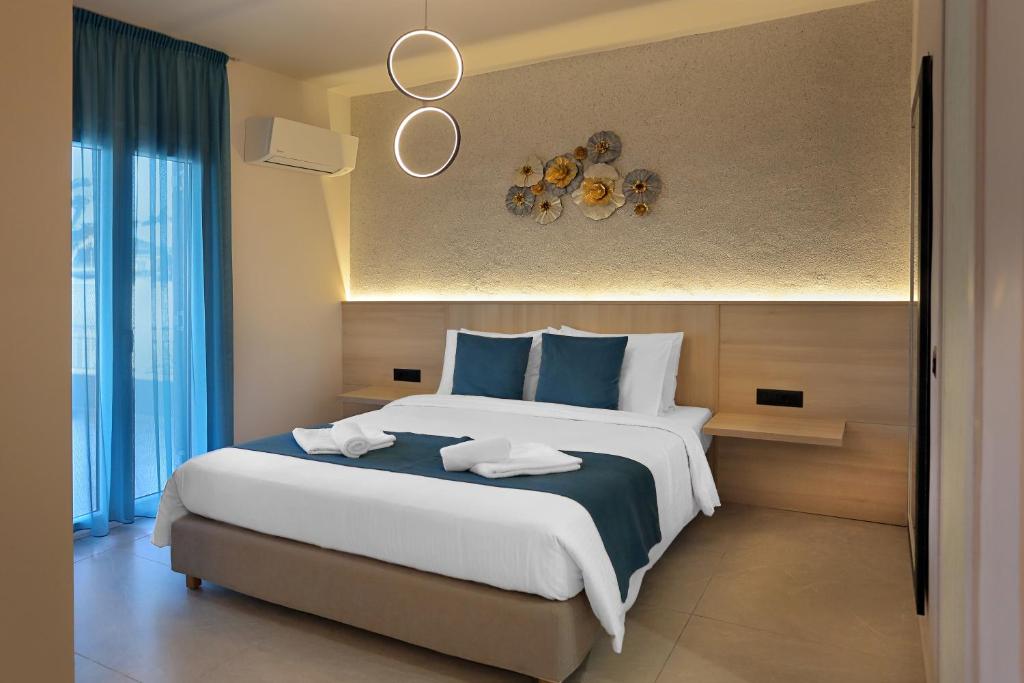 a bedroom with a large bed with blue pillows at AMMOESSA APARTMENTS in Plataria