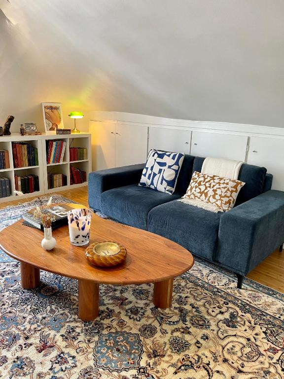 un salon avec un canapé bleu et une table basse dans l'établissement Charmant appartement parisien, à Paris