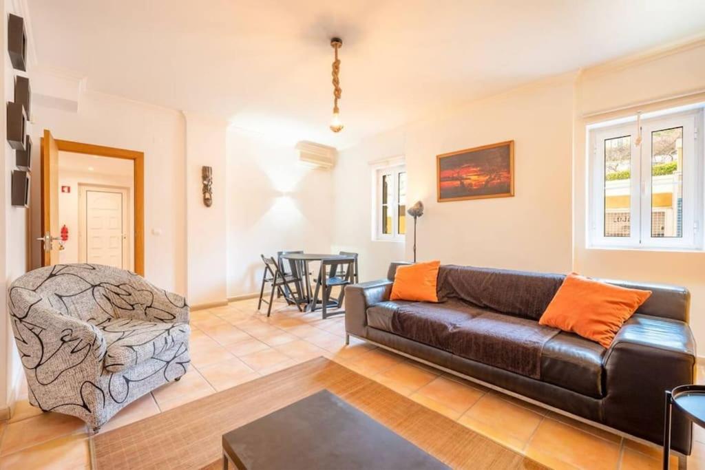 a living room with a leather couch and a table at Vila Margarida Beach Haven in Estoril
