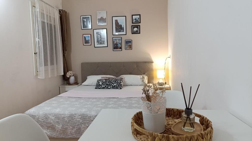 a white bedroom with a bed and a table at Apartment Mana in Mostar