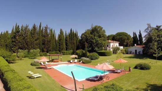 una gran piscina en un patio con sombrillas en Ghiaccio Bosco, en Capalbio